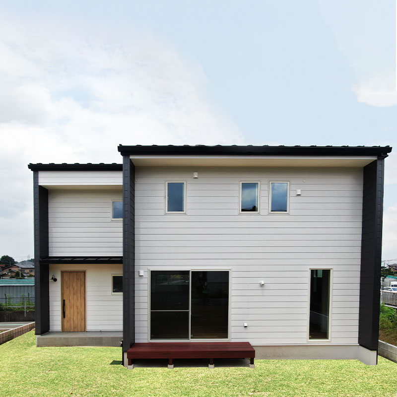 造作カウンターキッチンとウッドデッキのあるシンプルモダンな白い家