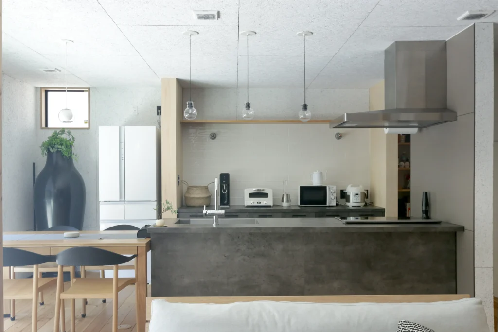 グレーでまとめたシンプルモダンなキッチン。ダイニングテーブルと続く動線は、配膳も楽々。