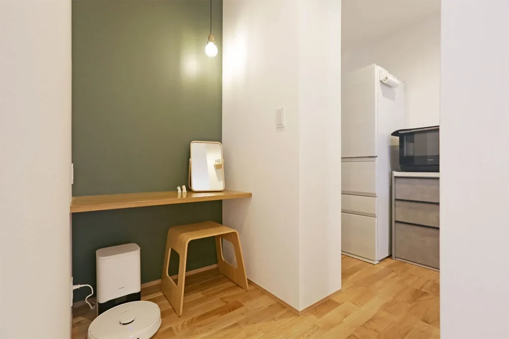 キッチンの隣の小さな空間に設けたワークスペース。正面を緑のアクセントクロスで仕上げて目に優しく。