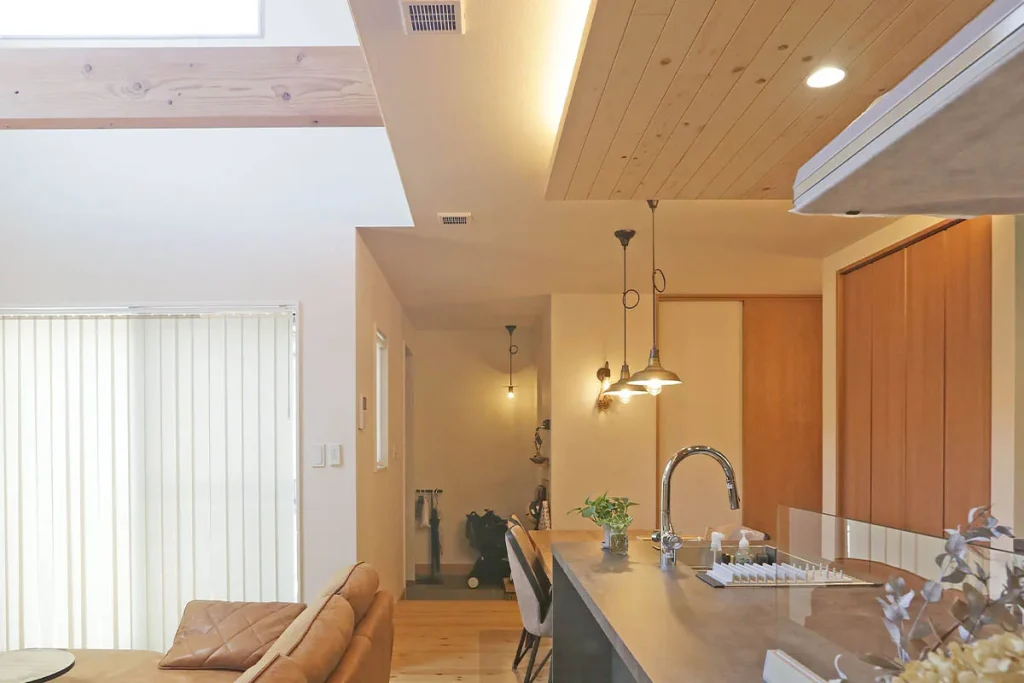 吹き抜けで開放的なリビングに対し、キッチンは下がり天井でさらにコントラストを。