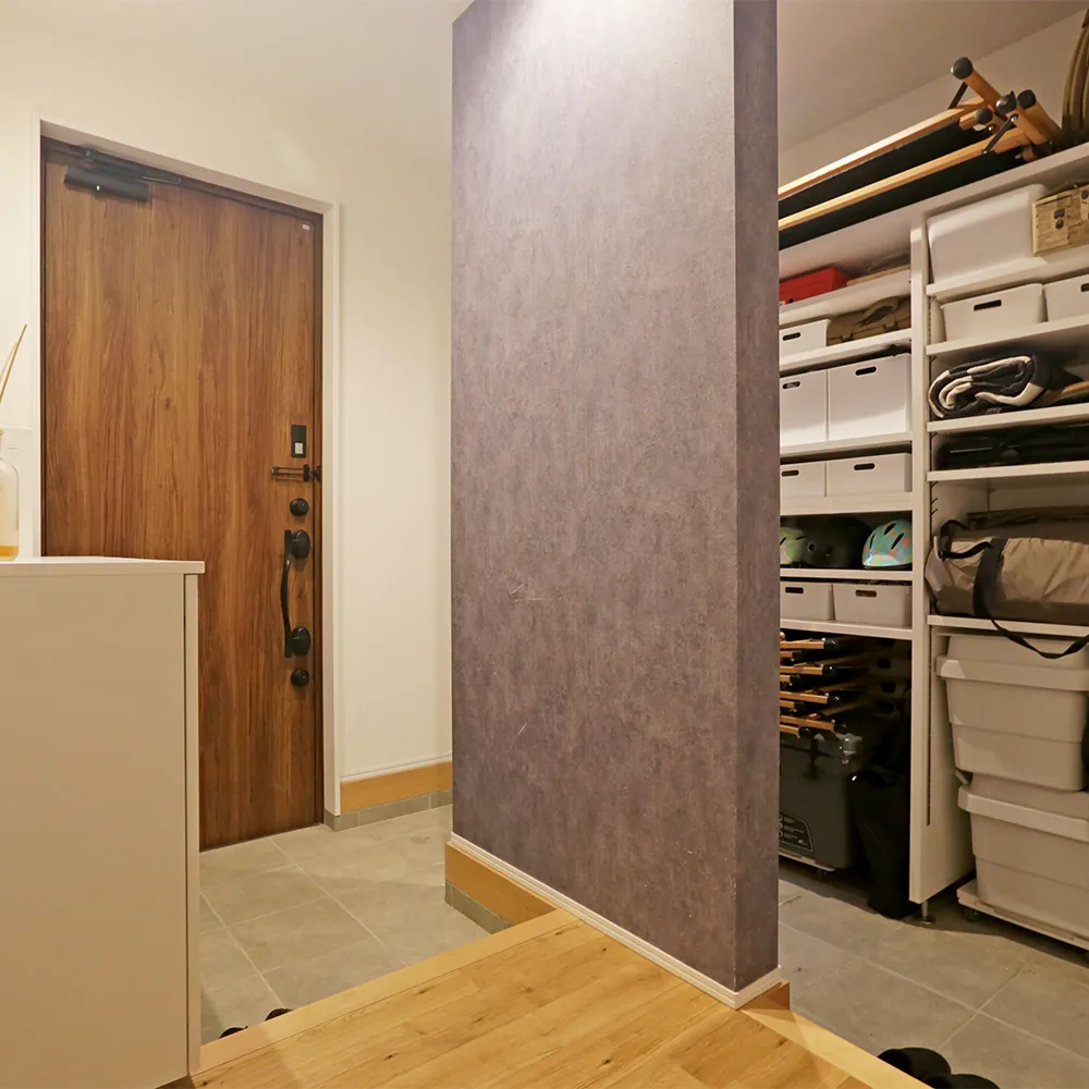 収納力たっぷりの玄関土間。アクセントクロスの壁は目隠しに。