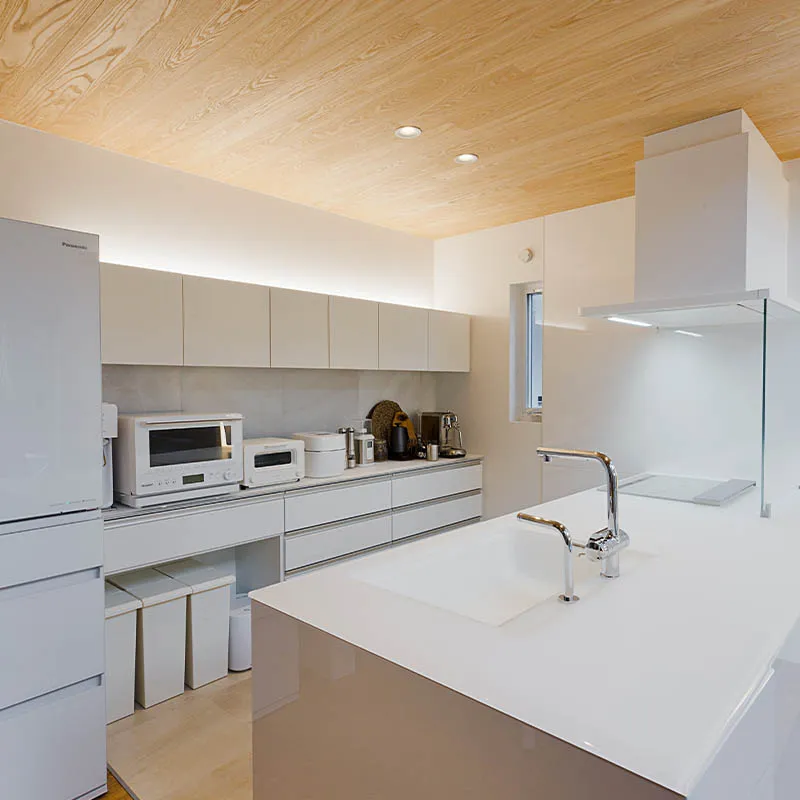 カップボードの上に照明を設置して、淡白になりがちなキッチンに上質感をプラス。