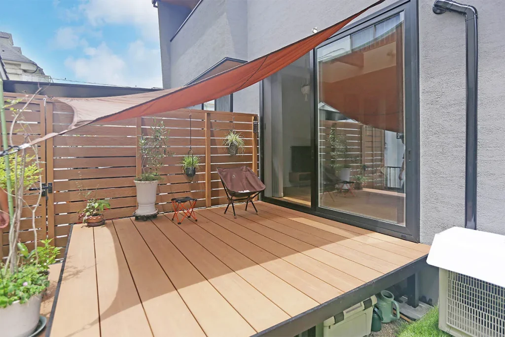 リビングとつながる中庭のウッドデッキ。タープを張ってプライベートなリラックス空間に。