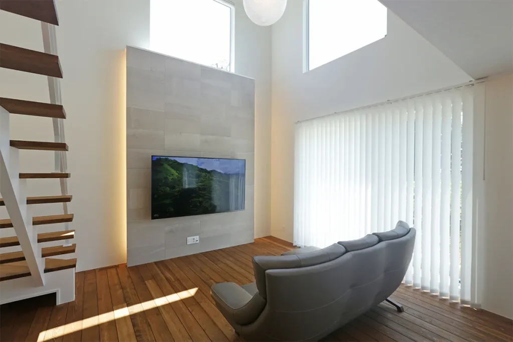 テレビボードに大理石風のエコカラットを採用。背面に間接照明を仕込んでホテルライクに。