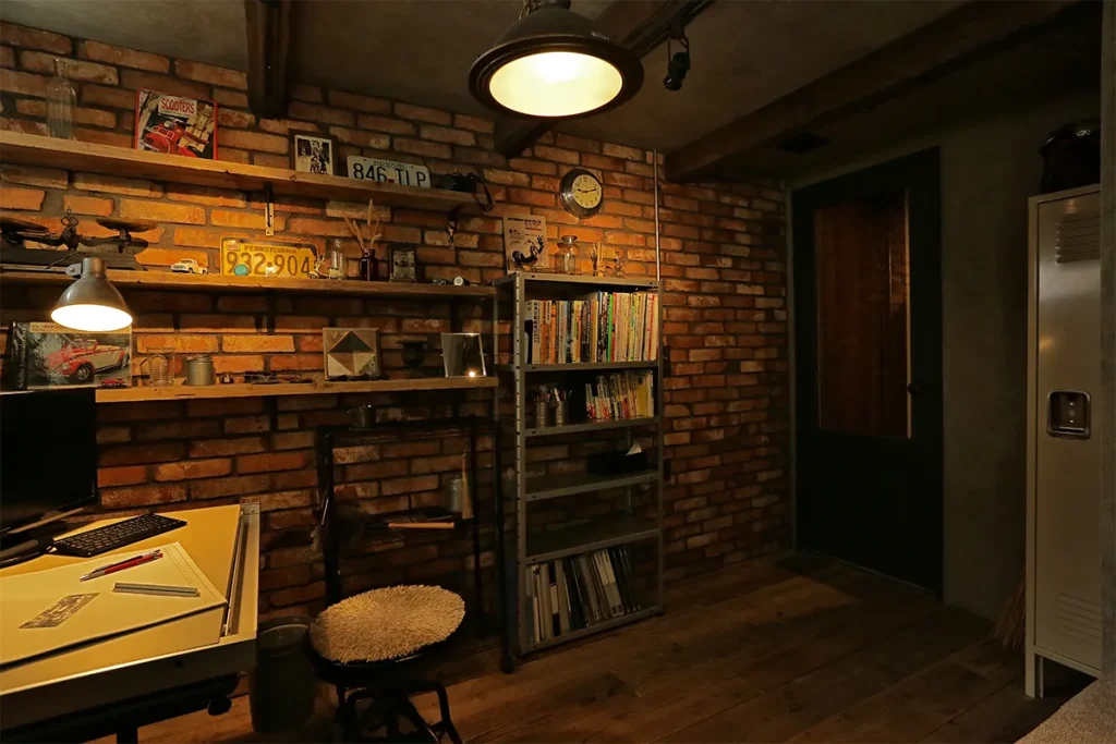 レンガ調のクロスとインダストリアルなインテリアを組み合わせ、秘密基地のような書斎に。