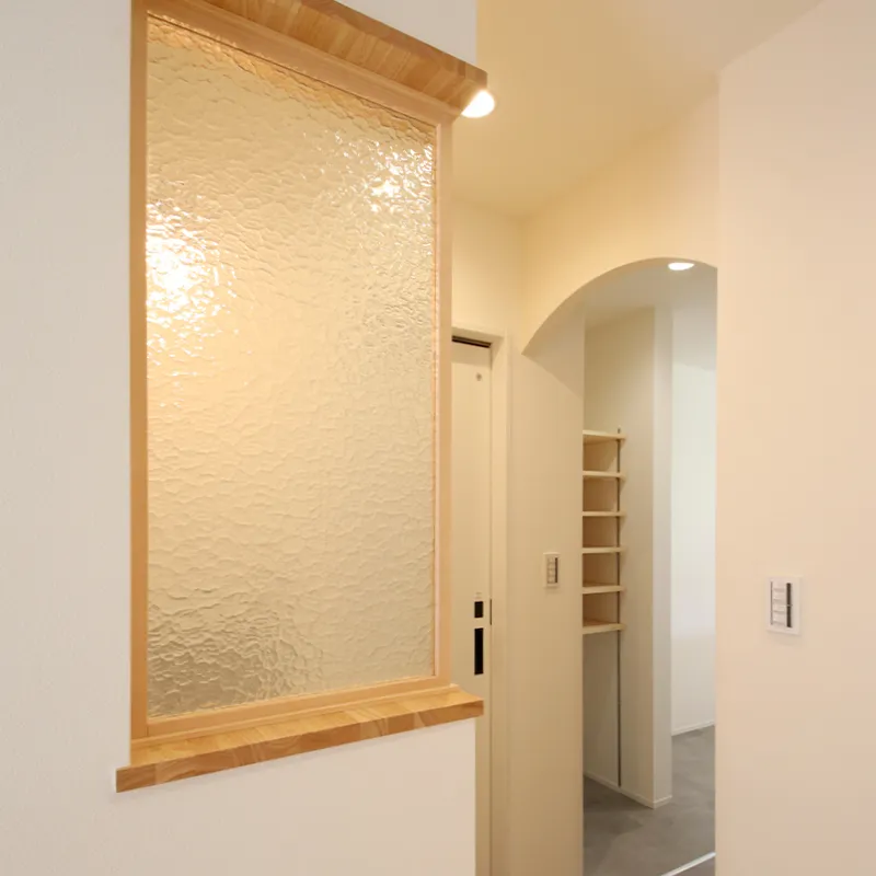 壁の端に設けたすりガラスの窓。灯りをふんわりと取り込むアクセント。