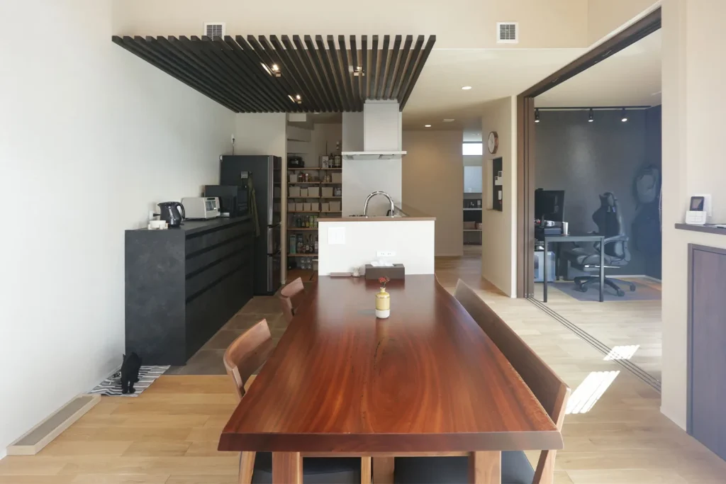 キッチンの上部を格子で下がり天井に。ブラックのカップボードとの組み合わせがクール。